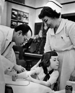 Dr Jonas Salk with one of the first children to receive the vaccine. © WHO