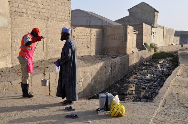 Environmental surveillance officers in Nigeria check a water source for evidence of polio. 