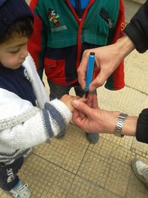 A young boy has his finger marked after polio vaccination