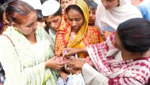 Mobile polio immunization teams walk from house to house to vaccinate newborn babies