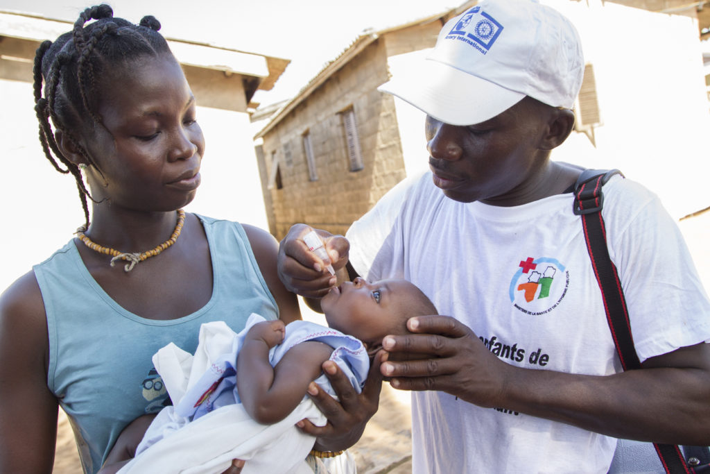 A mother helps to reduce outbreak risk by allowing her child to be immunized. © WHO
