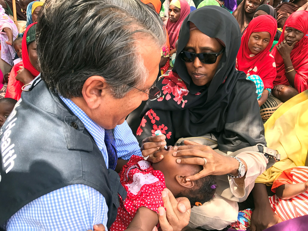 In Somalia, a Member State of the Organization of Islamic Cooperation, Minister of Health Dr Fawziya Abikar Nor (right), and Dr Ghulam Popal, WHO Representative for Somalia, vaccinate a child against polio. ©WHO / A.Wolasmal