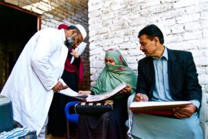 EPI Vaccinators and CBVs refer to Routine Immunization Register during visit to an urban slum, Sikandar Town Peshawar. ©UNICEF/ Kyinat Motla