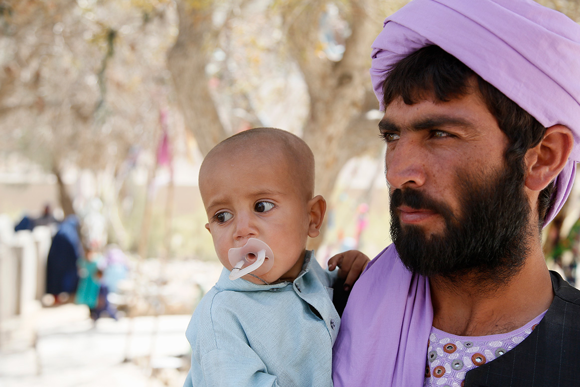 A father waits to have his baby vaccinated against polio in Kandahar, Afghanistan. © WHO / Jawad Jalali