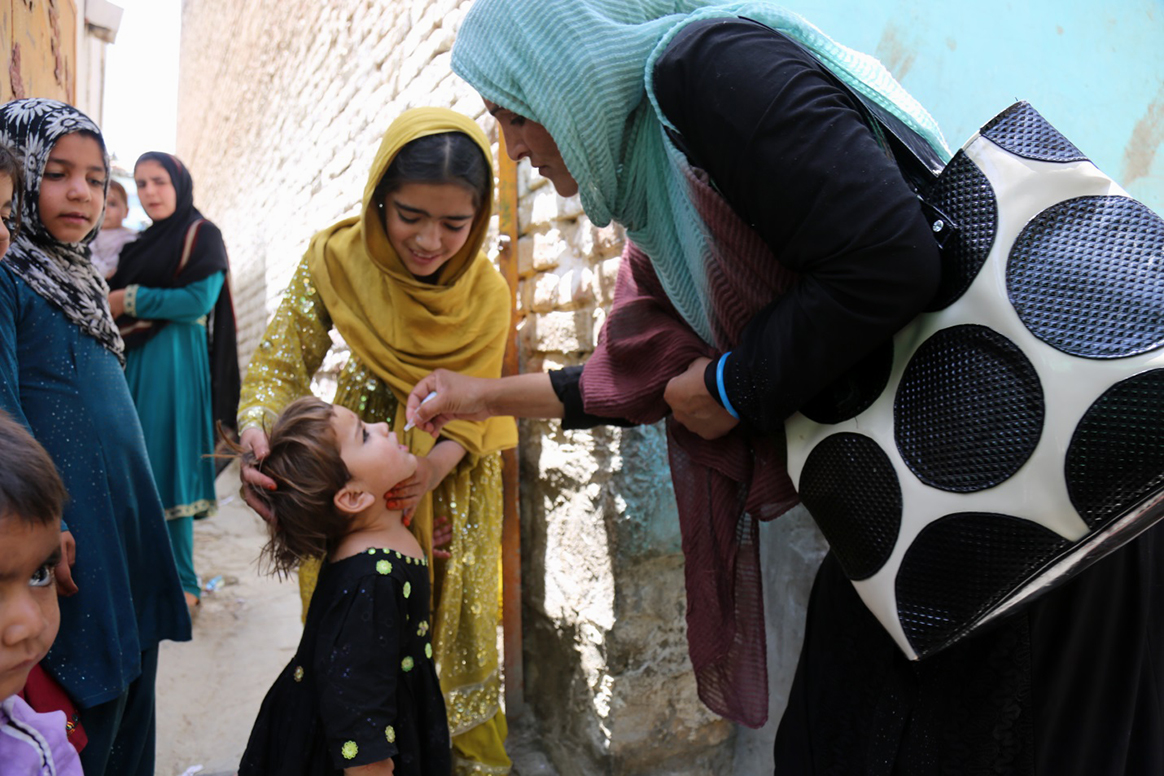A female vaccinator administers polio vaccine during a campaign in Kabul, Afghanistan. © WHO/J Swan