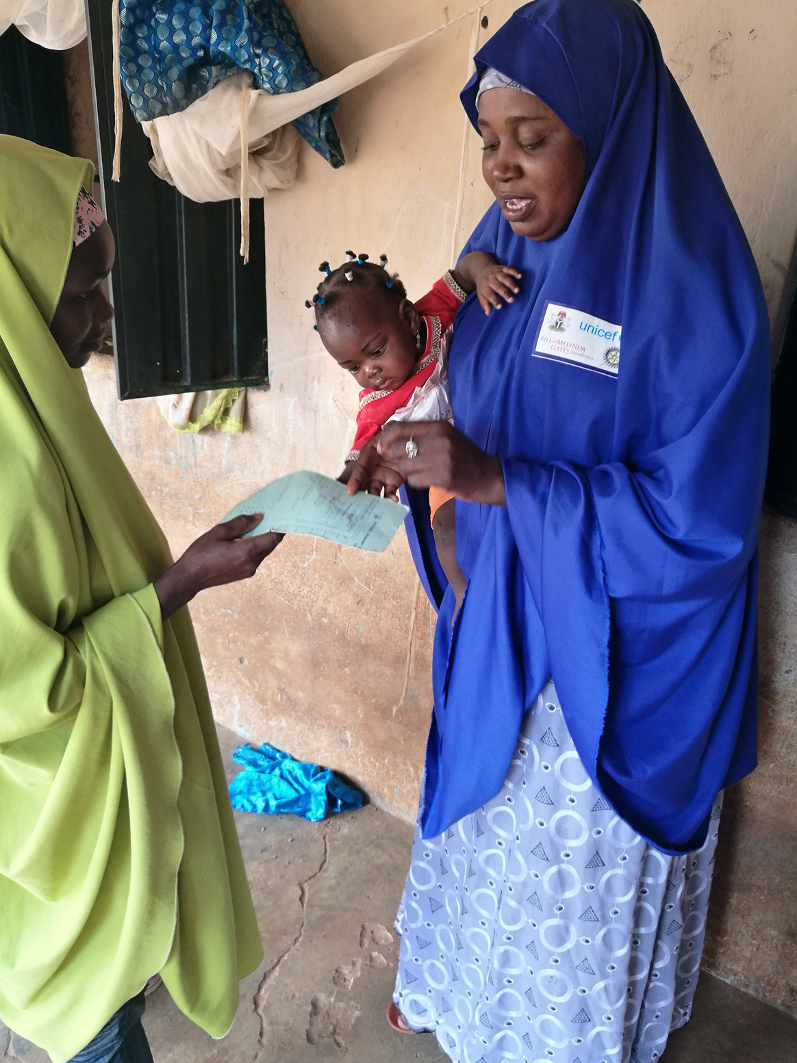 Hauwa inspects a baby’s vaccination card. By building up trusting relationships with her community, her health advice gains credibility. © UNICEF/Nigeria