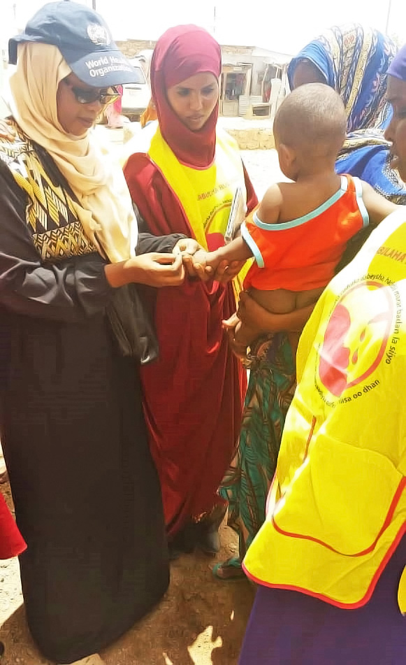 Dr Rehab Kambo vaccinating a young child in Somalia. © WHO Somalia