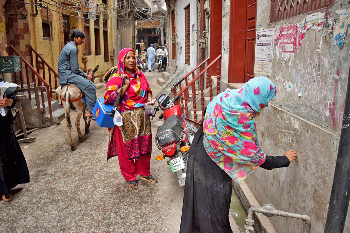 A polio team doing marking a door in Ravi Town, Lahore during NID III © WHO/A.Khan
