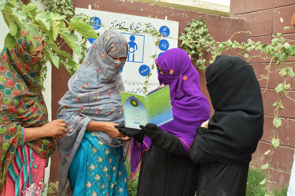 Asma showing women the polio fatwa book during one of the polio training sessions. © S.Gull/WHO Pakistan