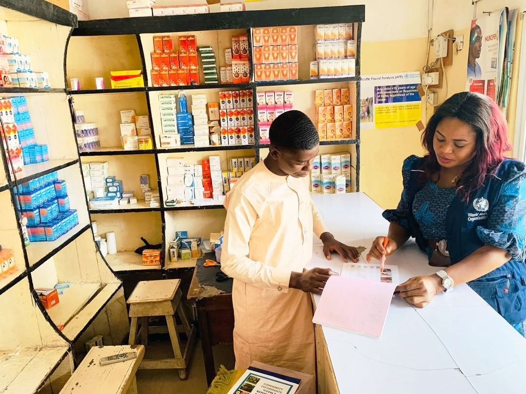 Dr Alhassan explains the key signs of acute flaccid paralysis to a pharmacist in Borno State. ©WHO/Nigeria