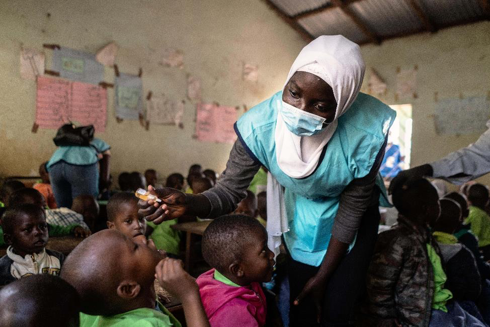 Sainabou, a healthcare worker, administers the polio vaccine to school children at New Town School during a vaccination campaign in Bakau, The Gambia, on 19 March 2022. Photo: © UNICEF/UN0624057/Lerneryd