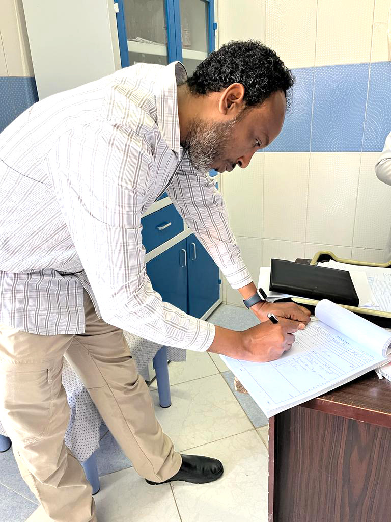 Dr Abdinoor reviewing documents at a health facility. All major health facilities in Afghanistan have an AFP focal point who acts as the link between the facility and the broader polio surveillance system. © WHO