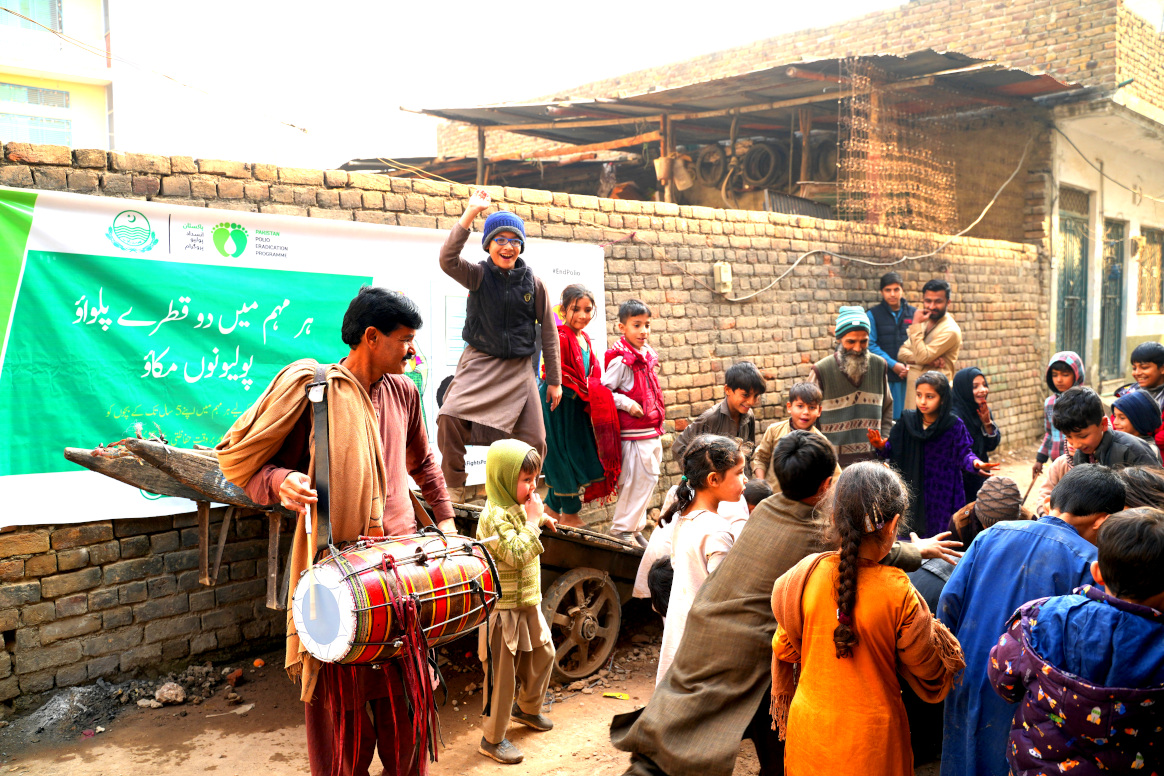 Zafar, the drummer, uses his rhythmic beats to attract a crowd of children and adults to share information about the upcoming polio campaign, in a neighborhood in Rawalpindi, Punjab, Pakistan. © UNICEF/Pakistan