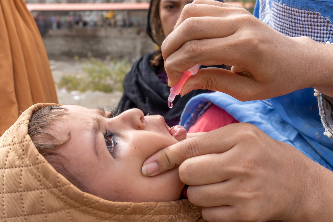 A child receives polio drops as part of the routine immunization service at a temporary health facility near the Torkham border crossing in Eastern Afghanistan. © UNICEF/UNI530949/Karimi